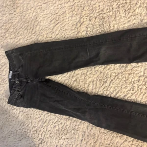 Svarta jeans från Replay - Snygga svarta jeans från Replay med en klassisk femficksdesign. De har en diskret logga på bakfickan och är perfekta för en stilren look. Jeansen har en knappgylf och är tillverkade i ett bekvämt material som ger en bra passform. Lågmidjade