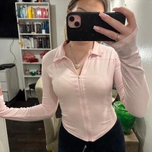 Rosa långärmad tröja med dragkedja - Säljer denna fina zip Tröja med hål för tummarna, färgen passar gina tricots rosa byxor perfekt 