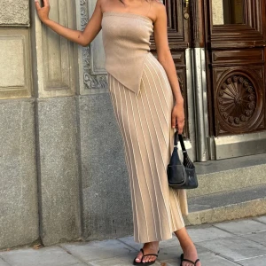 Lausanne Bandeau Dress Adoore - Snygg beige klänning från Adoore i storlek 38 i modellen Lausanne Bandeau Dress. Helt ny med lappar kvar. Nypris 1 495kr.