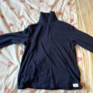 Mörkblå polotröja från Lefties - Säljer en stilren mörkblå polotröja från Lefties. Tröjan har långa ärmar och en klassisk polokrage, perfekt för kyligare dagar. Passar barn i åldern 7-8 år. Ett mångsidigt plagg för garderoben!