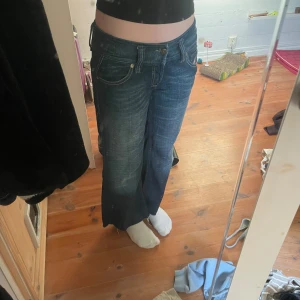 Low waist diesel jeans - Säljer ett par snygga blå jeans från Diesel, modell Lambry. De har en klassisk femficksdesign med dekorativa broderier på bakfickorna. Jeansen har en lågmidjad passform och är tillverkade i slitstarkt denim. Priset går att diskutera!!!