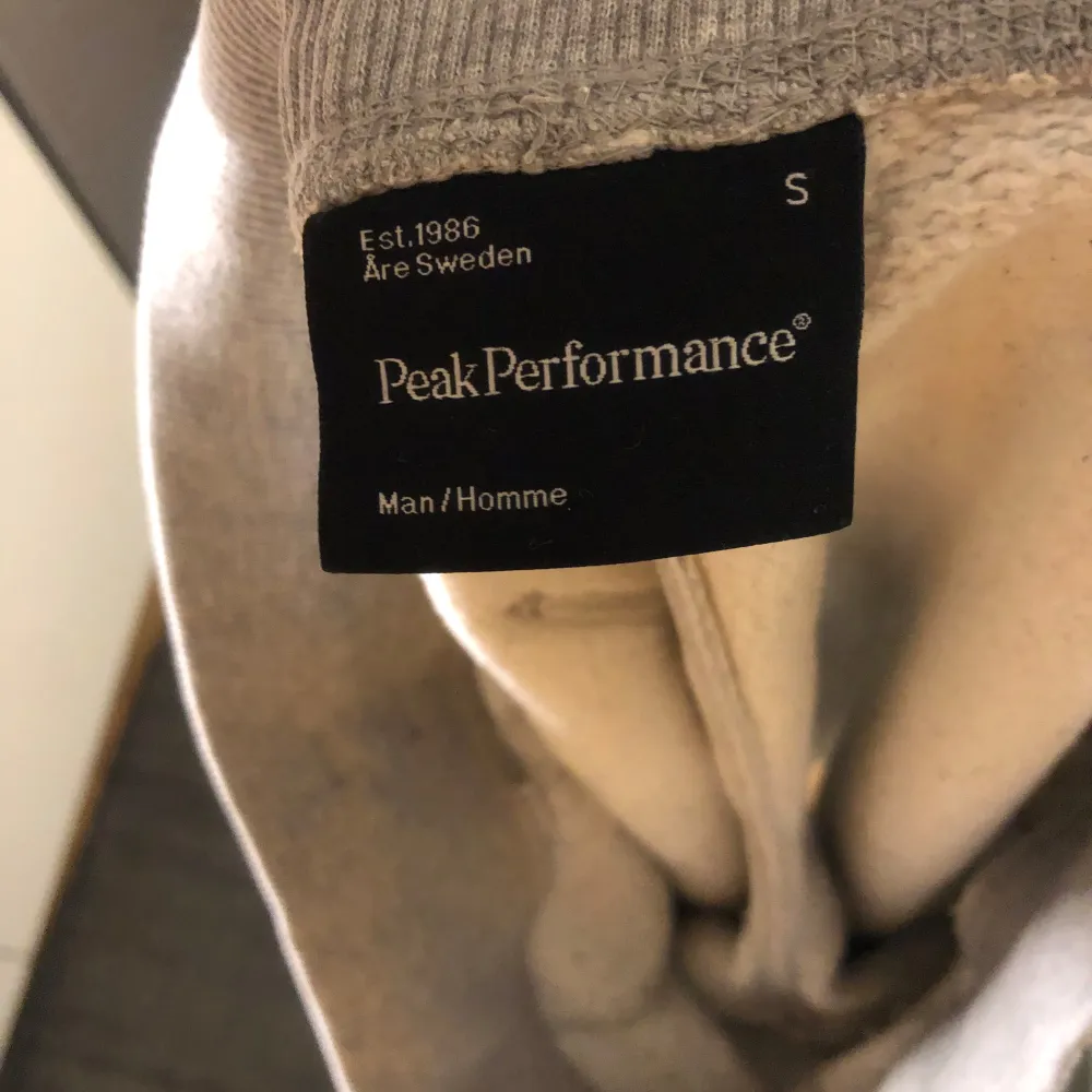 Säljer ett par grå shorts från Peak Performance med lila snörning i midjan och en bakficka med tryck. Perfekta för en avslappnad stil.. Shortsit.