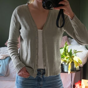 Grön kofta från Casual Wear Adelsten - Säljer en  pistagegrön kofta från Casual Wear Adelsten. Koftan har en v-ringad design med knappar framtill. Har inga defekter och är i storlek 38/40. Bara att skriva om ni har frågor 