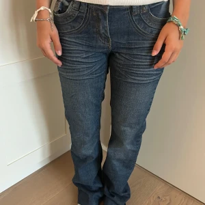 Blå Replay jeans low hip bootcut - Säljer ett par blå jeans från Replay med low hip-passform och bootcut-ben. Snygga kontrastsömmar och coola bakfickor med broderade detaljer. Klassisk femficksmodell i jeansmaterial, perfekt för dig som gillar en avslappnad men trendig look.
