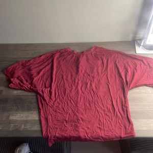 Röd basic t-shirt i bomull, som går in vid midjan - Enkel röd t-shirt med korta ärmar och rund hals. Modellen är loose fit och passar perfekt till jeans eller shorts. T-shirten är gjord i mjuk bomull och har en avslappnad vibe.