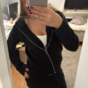 Svart zip hoodie från H&M - Svart zip hoodie från H&M med dragkedja framtill och två fickor. Jackan har huva med snören och är tillverkad i mjuk bomullsmix. Perfekt för chill dagar eller när du vill ha en enkel och stilren look.