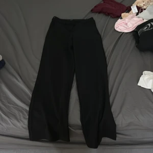 Svarta wide byxor från Vero Moda - Snygga svarta byxor från Vero Moda i storlek XS. Byxorna har en rak och vid passform med hög midja och är tillverkade i ett mjukt och följsamt material. Perfekta för en clean och stilren look.