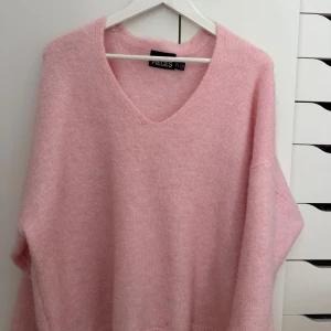 Rosa stickad tröja - Säljer denna super söta rosa stickade tröjan från Nelly. Endast använd en gång, väldigt bra skick💖hör av er vid frågor om priset eller annat.