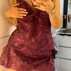 Lila genomskinlig spetsklänning - Superfin lila kortklänning från Secret Treasures med blommigt mönster i mesh. Klänningen har tunna axelband, v-ringning och är gjord i 100% polyester. Perfekt för dig som vill sticka ut med en romantisk och trendig look. Supergulligt, däremot aldrig använt