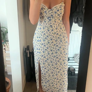 Blommig långklänning med slits - En klänning som går till vaderna från Bershka som är använd 2-3 gånger.