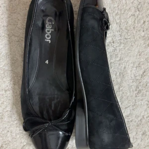 Svarta ballerinaskor från Gabor - As snygga svarta ballerinaskor från Gabor, nypris ca 1000 kr. Lackad tå och söt rosettdetalj framtill. Skorna har mocka på sidorna och en klassisk rund tå. Använda fåtal gånger💕Skulle säga att strl är ca 37