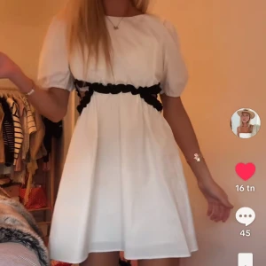 Vit kortklänning med svarta detaljer - Superfin vit kortklänning med puffärmar från Zara i storkel 156 men passer xs. Perfekt för dig som gillar en söt och trendig stil. Klänningen säljs ej längre men såldes för runt 500. Den är använd en gång men det syns inte! 