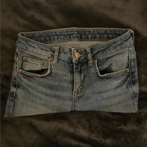 Blå jeanskjol  - Snygg blå jeanskjol från gina tricot som är omsydd. Kjolen är kort och har en cool tvättad look med slitna detaljer och kontrastsömmar. Perfekt för dig som gillar en avslappnad och trendig stil.