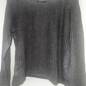 Stickad tröja från Gina Tricot - Säljer en gråmelerad stickad tröja från Gina Tricot i storlek L. Tröjan har en rak passform, rund halsringning och långa ärmar. Materialet är en mix av bomull och akryl, vilket gör den både mjuk och skön. Perfekt för lager-på-lager under kyliga dagar.
