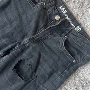 Svarta jeans från LAB Industries - svarta bootcut jeans från Kappahl. Har gjort hålen själv. Är i storlek 152 men upplevs större för de är stretchiga. 
