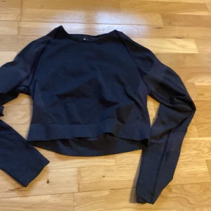 Svart långärmad tröja från 157 - En svart långärmad tröja från 157 i storlek medium. Tröjan har en enkel och stilren design med rund halsringning och något croppad passform. Perfekt för en chill och avslappnad look.