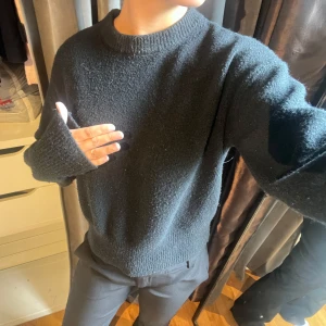 Svart stickad tröja från BikBok - Mysig svart stickad tröja från BikBok med rund halsringning och långa ärmar. Tröjan har en lite loose passform och ribbade muddar vid ärmslut och hals. Perfekt för lager-på-lager under kyliga dagar.