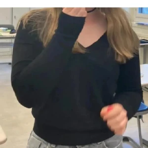 Svart v-ringad tröja från H&M Basic - En svart v-ringad tröja från H&M Basic med lång ärm och ribbade muddar. Enkel och stilren modell som passar perfekt till jeans eller kjol. Tillverkad i mjuk bomullsmix för en skön känsla hela dagen.