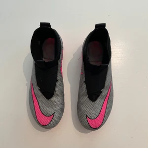 Nike Air Zoom Mercurial Superfly 9 Pro FG – Strl 38 – Fint skick + Inlägg - Snabba och lätta fotbollsskor – perfekt för match och träning! Lite använda Nike Air Zoom Mercurial Superfly 9 Pro FG i storlek 38. Färg: silver/rosa/svart/neon. Fint skick och mycket bekväma tack vare Zoom Air-dämpning och utmärkt grepp på planen. Nypris för skorna: 1 699 kr. Ortho Movement Football Insole (värde 339 kr) ingår.  Finns i Spånga