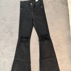 Svarta bootcut jeans med hål - Svarta jeans med bootcut-modell och slitna hål vid knäna. Använd ett fåtal gånger. Skriv för fler bilder😊
