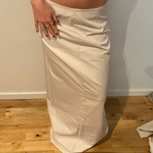 Beige långkjol i  - Snygg beige långkjol med rak passform och hög midja. Perfekt för dig som gillar minimalistisk stil och vill ha en enkel men trendig kjol.