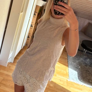 Beige ärmlös polotopp  - Säljer en superfin beige ärmlös polotopp från Stradivarius. Toppen har en hög ribbad krage, och materialet är mjukt och skönt. Funkar både att använda till mer fina tillställningar och till vardagen! Samt jättefin till hösten🤎🍁
