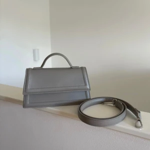 Gina tricot väska  - Säljer denna superfina väska från Gina i en mörk grå färg. Aldrig använd men tyvärr så har jag tagit bort prislappen. Inga märken på den, som ny!🤍