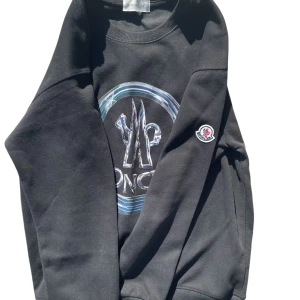 Svart Moncler sweater - Säljer en moncler tröja. Jag vet inte om den är äkta, men den ser bra ut. Jag köpte den från en svensk tik tokare. Tröjan sitter bra på mig. Jag använder storlek S. Den passar inte M. Ta gärna kontakt vid eventuella frågor eller bilder😊. 