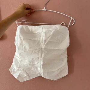 Ny vit tubtopp från Pull&Bear - Säljer en snygg vit bandeau tubtopp från Pull&Bear i storlek L som är helt ny med prislapp. 🩷 Alfrig använd bara prövat☺️