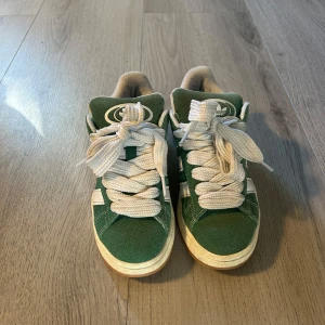 Adidas Campus  - Gröna Adidas Campus sneakers med tjocka vita snören. Inte använda speciellt mycket så de är i gott skick, inga defekter😊