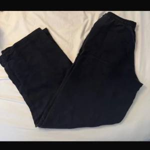 Svarta linnebyxor med resår - Mörka svarta linnebyxor med rak passform och elastisk midja. Byxorna har två stora bakfickor och är tillverkade i mjuk manchester, perfekta för en chill och avslappnad stil.