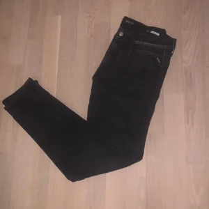 Svarta Replay Anbass jeans herr - Säljer ett par svarta Replay Anbass jeans i klassisk slim fit. Jeansen har snygga detaljer vid fickorna och diskret Replay-logga. Modellen är modern med smal passform och stretchigt jeanstyg som sitter riktigt bra.