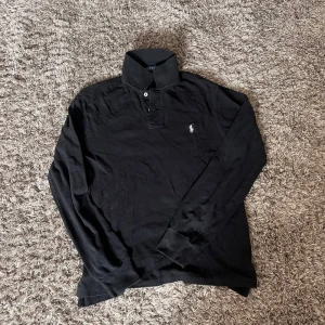 Svart pikétröja från Polo Ralph Lauren🤩 - Klassisk svart långärmad pikétröja från Polo Ralph Lauren i slim fit. Piken är i storlek M men passar mer än S🤩
