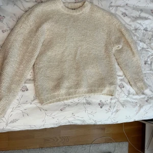 Beige stickad tröja från Gina Tricot - Supermysig beige stickad tröja från Gina Tricot i storlek XS. Tröjan har en fluffig och chunky struktur, rund halsringning och långa ärmar. Perfekt för lager på lager och chill höst- och vinterstil.
