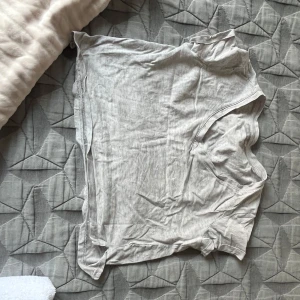 Ljusgrå v-ringad t-shirt XS - En enkel och mjuk ljusgrå t-shirt från Bestshirt i storlek XS. T-shirten har v-ringad hals och korta ärmar, perfekt för chill dagar. Materialet är bomull och passformen är normal. Snygg att matcha med jeans eller shorts.