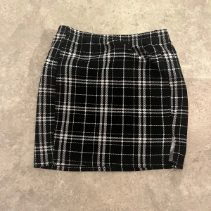 Svartvit rutig kjol från SHEIN - Snygg svartvit rutig kortkjol från SHEIN. Kjolen har klassiskt rutmönster och rak passform, perfekt för dig som gillar en stilren och trendig look. Tillverkad i mjukt och bekvämt material som passar till många olika outfits.