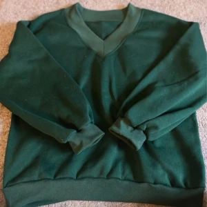 Grön sweatshirt med v-ringning - Mörkgrön sweatshirt med v-ringad hals och långa ärmar. 