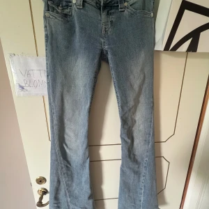 True Religion Joey Low Rise Flare Jeans - Jag säljer mina true religon jeans för att de är för stora för mig! Jag har använt dom kanske 5 gånger! Snygga ljusblå jeans från True Religion, modell Joey Low Rise Flare. De har låg midja, utsvängda ben och klassiska detaljer som markerade bakfickor med lock och logoknapp. 