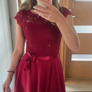 Vinröd spetsklänning med rosett - Säljer en vinröd kortklänning med spets upptill och glittriga detaljer🫶🏼använt två gånger💓original pris 160€