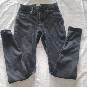 Svarta skinny jeans från 157 - Svarta jeans med skinny fit från 157, klassisk femficksmodell och dragkedja i gylfen. Snygg mörk tvätt och smal passform som sitter tajt längs benen. Perfekta för dig som gillar en stilren och enkel look.