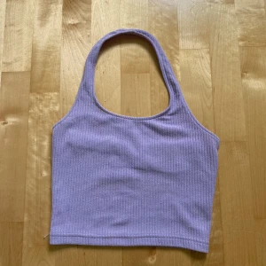 Ljuslila ribbad linnetopp H&M Divided - Superfin ljuslila ribbad linnetopp från H&M Divided. Toppen har en croppad passform med breda axelband och ärmlös design. Perfekt till jeans eller kjol för en chill och trendig look. Mjuk och stretchig bomullskvalitet som sitter skönt hela dagen.