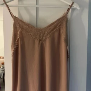 Linne med spets  - Ett fint beiget linne med spets. Banden går att justera, bra skick!