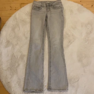 Ljusgrå bootcut jeans - Snygga ljusgrå lågmidjade bootcut jeans från Gina tricot i storleken 32. Originalpris: 499kr