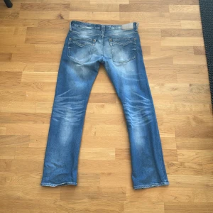 Blå Replay jeansbyxor herr W31 - Säljer ett par klassiska blå Replay jeans med slitningar och raka ben. Byxorna har fem fickor, gylf med dragkedja och knapp samt Replay-logga på bakfickan. Perfekta för dig som gillar en avslappnad stil. Nypris ligger runt 999, mitt pris 249! Pris går att diskuteras! Hör av er vid minsta lilla fundering🤗