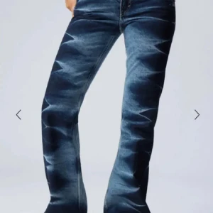 Weekday jeans med mönster - Snygga blå bootcut jeans med unikt ljust zigzag-mönster längs benen. Jeansen har klassisk femficksdesign och dragkedja framtill. Perfekta för dig som vill sticka ut med din stil.