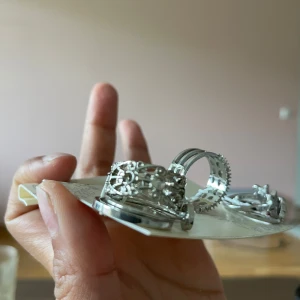 Sats med silvriga ringar från Muda - Säljer ett set med fem silvriga ringar från Muda. Ringarna har olika mönster, bland annat stjärnor, hjärtan och gnistrande detaljer. Perfekt för att mixa och matcha för en unik stil size:6. 16.5mm