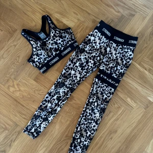 Leopardmönstrade träningstights från Stronger - Snygga leopardmönstrade träningsset från Stronger. Tightsen är stretchiga och sitter tight, perfekta för gymmet eller löpning samma med toppen. Båda är i xs och har inga defekter 