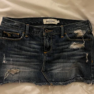 Lågmidjad jeanskjol  - Jättefin jeanskjol från abercombie & fitch u storlek 14 år. Skulle säga att den motsvarar en xxs-xs. Jättefint skick och säljer då den är för liten för mig. Midjemåttet är ca 37-38 cm rakt över. Skriv för frågor, tryck gärna köp nu!           (Kan inte skicka bilder på då den inte passar)💕💕