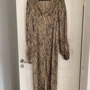 Adoore Positano dress - Säljes Adoore Positano dress beige Zebra i storlek 36. Enbart använd en gång, men tyvärr för liten för mig så jag behöver byta till strl 38.  Byte till en strl 38 är intressant!  Annars säljes den för 1400kr, nypris är 1695kr.