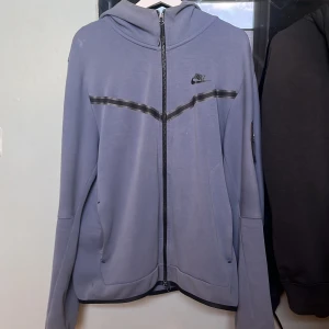 Ljuslila hoodiejacka från Nike - Jag säljer min Nike teech hoddie (gamla modellen) då den inte passar mig längre och den knappt används. Den är i bra skick och väldigt fräsch! Färgen är lite blå/ turkos. Väldigt fräsch färg att ha på sig.  